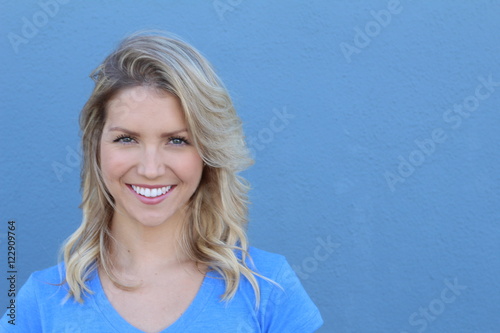 Woman portrait with beautiful blond hair smiling and laughing - isolated over a blue background with copy space  © ajr_images
