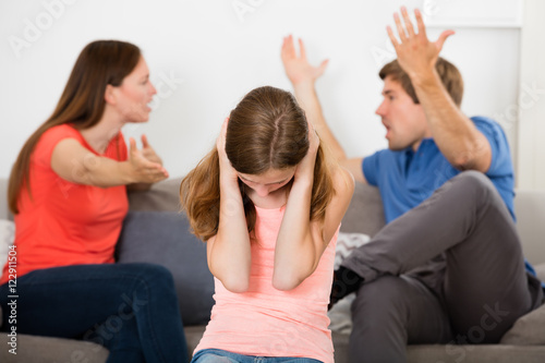 Upset Girl In Front Of Parent Having Argument