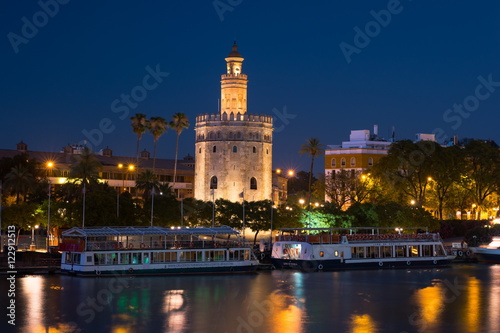 View of Golden Tower, Torre del Oro, of Seville, Andalusia, Spain over river Guadalquivir at sunset. Beautiful sunset view.