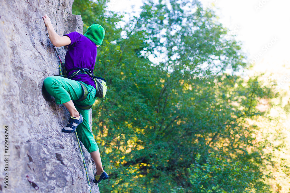 The girl climbs the rock.