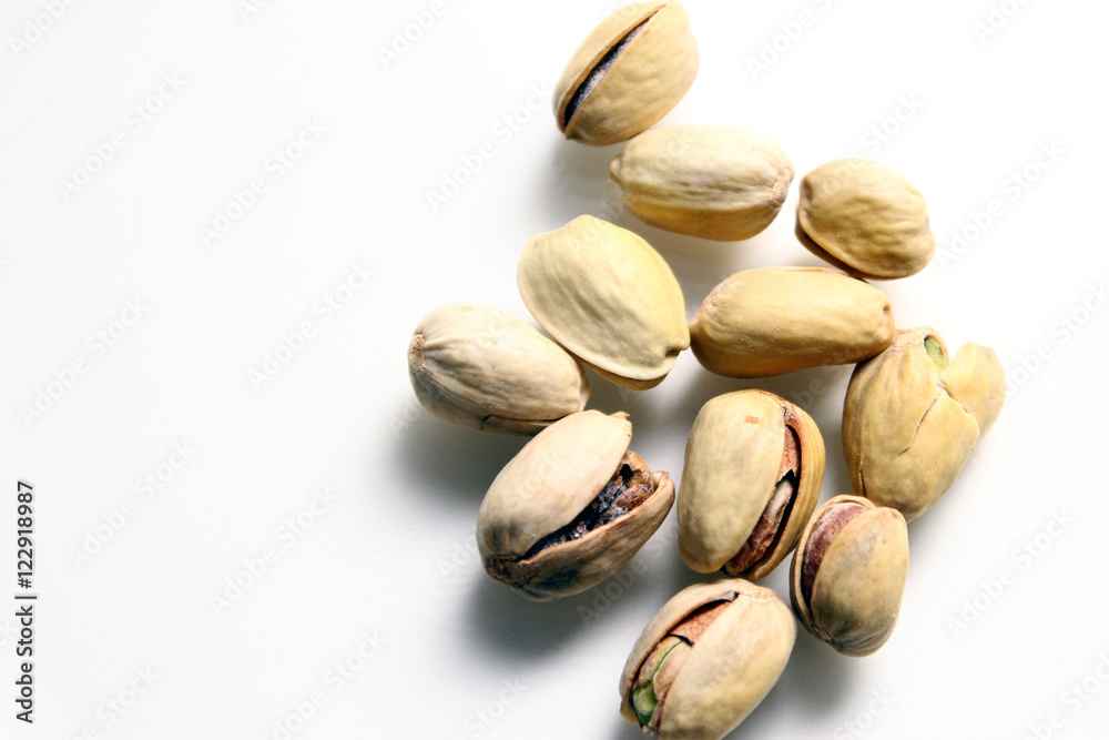 Pistachio in white background / Wonderfully delicious pistachio nuts have long been revered as the symbol of wellness and robust health since ancient times Pistachio in white background / Wonderfully delicious pistachio nuts have long been revered as the symbol of wellness and robust health since ancient times