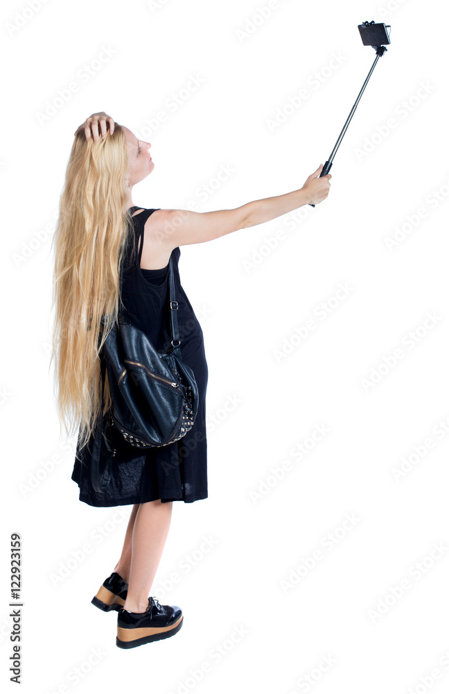back view of standing young beautiful girl with tablet computer in the hands of. girl watching. Rear view people collection. backside view of person. Isolated over white background. The girl with back view of standing young beautiful girl with tablet computer in the hands of. girl watching. Rear view people collection. backside view of person. Isolated over white background. The girl with