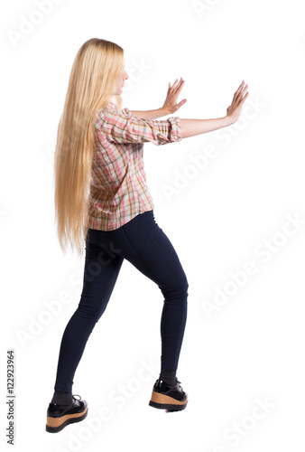 back view of woman pushes wall. Isolated over white background. Rear view people collection. backside view of person. Girl with very long hair that shoves his hands in his side.