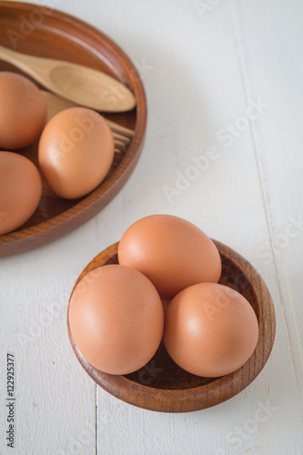 Egg in a wooden bowl on wooden table white. Chicken Egg. Top view with copy space