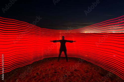 Light painting with red lights on beach