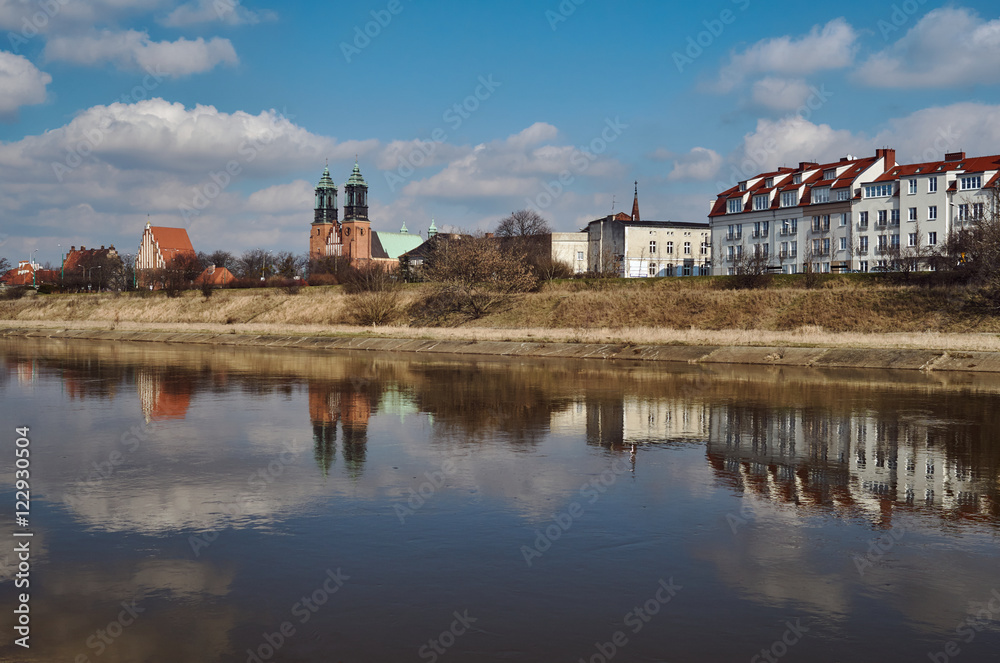 Urban landscape with river Warta, the cathedral towers and residential houses in Poznan.