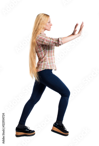 back view of woman pushes wall. Isolated over white background. Rear view people collection. backside view of person. Girl with very long hair shoves something in front of him.