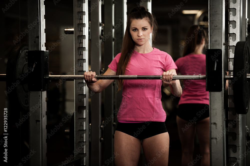 Woman workout in fitness gym with barbells - powerlift workout Woman workout in fitness gym with barbells - powerlift workout