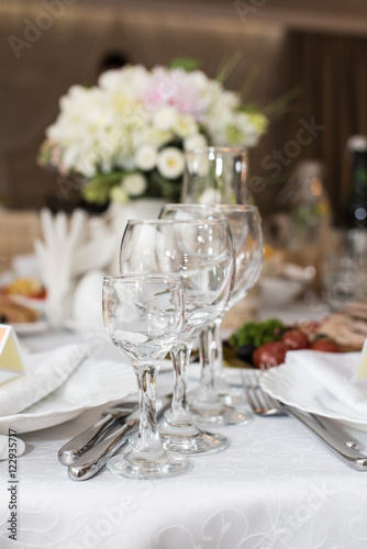 Wedding decoration with wine glasses, flowers and cutlery