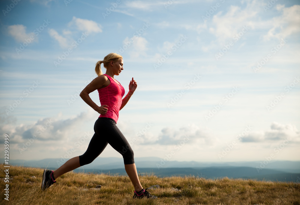 runner - woman runs cros country on a path in early autumn runner - woman runs cros country on a path in early autumn