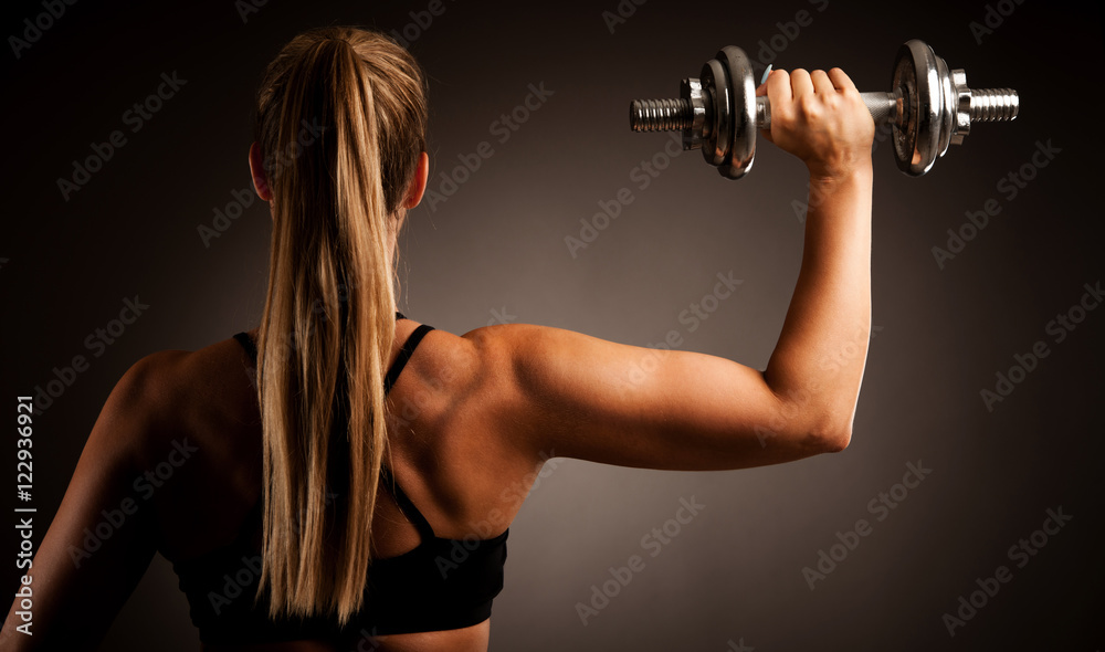 fit woman workout with dumbbells in gym studio photography of a