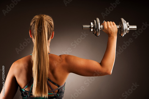 fit woman workout with dumbbells in gym studio photography of a