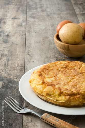 Traditional spanish omelette with potatoes and eggs on wooden table

