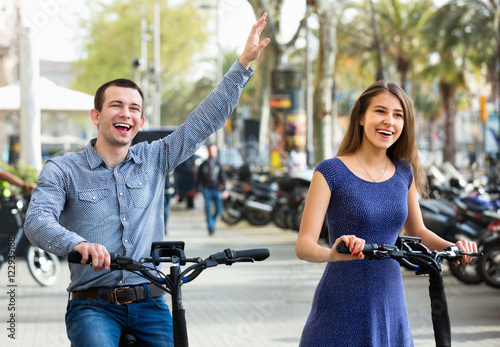 Happy young man and woman with electrkc bikes photo