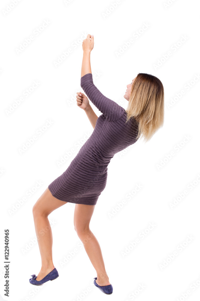 back view of standing girl pulling a rope from the top or cling to something. girl watching. Rear view people collection. backside view of person. Isolated over white background. Girl in dress from back view of standing girl pulling a rope from the top or cling to something. girl watching. Rear view people collection. backside view of person. Isolated over white background. Girl in dress from