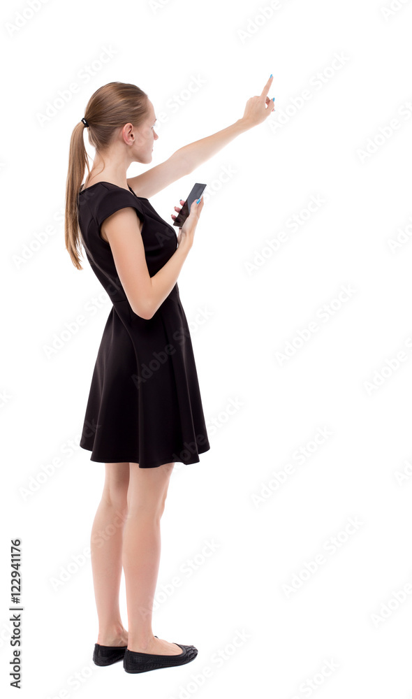 back view of pointing young beautiful woman and using a mobile phone. girl watching. Rear view people collection. backside view of person. Isolated over white background. back view of pointing young beautiful woman and using a mobile phone. girl watching. Rear view people collection. backside view of person. Isolated over white background.