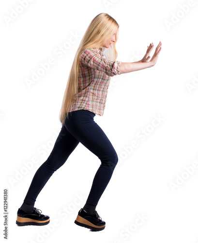 back view of woman pushes wall. Isolated over white background. Rear view people collection. backside view of person. Girl with very long hair put her hands on the wall.