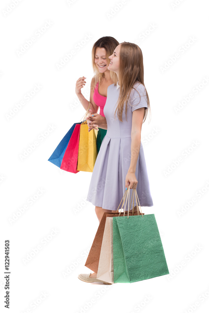 side view of two walking women with shopping bags. backside view of person. Rear view people collection. Isolated over white background. Two girls walk with shopping bags in their hands. side view of two walking women with shopping bags. backside view of person. Rear view people collection. Isolated over white background. Two girls walk with shopping bags in their hands.
