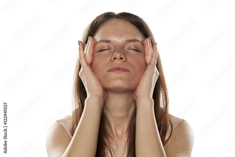 portrait of a young woman tightens the skin on her face portrait of a young woman tightens the skin on her face