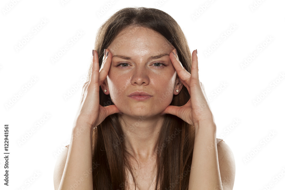 portrait of a young woman tightens the skin on her face portrait of a young woman tightens the skin on her face