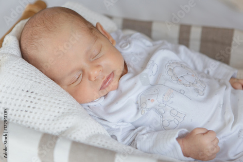 Newborn baby boy lying in a basket 
