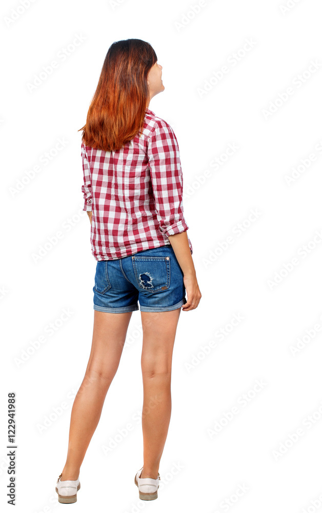 back view of standing young beautiful woman. girl watching. Rear view people collection. backside view of person. Girl in shorts and shirt looking up. back view of standing young beautiful woman. girl watching. Rear view people collection. backside view of person. Girl in shorts and shirt looking up.