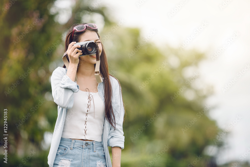 Asia woman photographer with camera outdoors at the park,travel concept