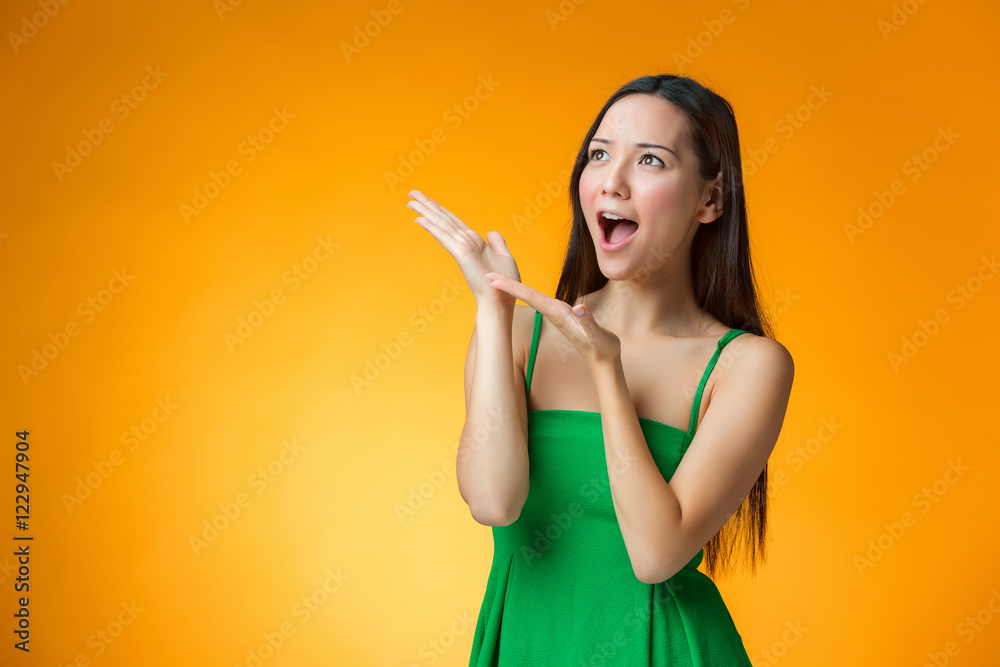 The surprised Chinese girl on yellow background The surprised Chinese girl on yellow background