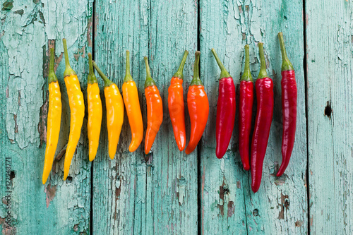 many vibrant colors on peppers , old wooden background
