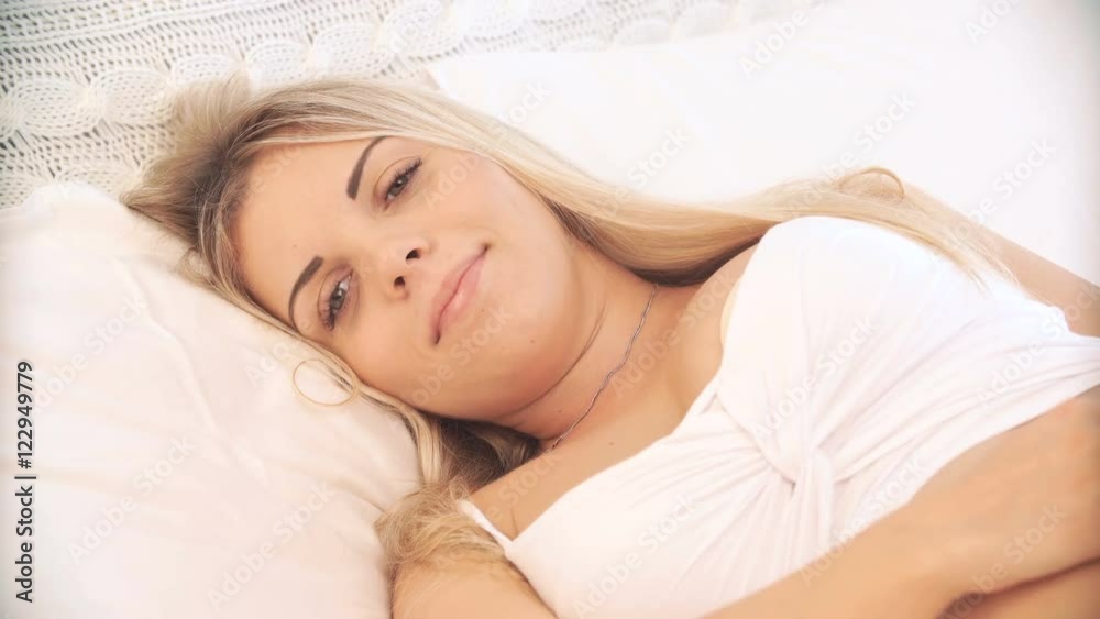 pregnant woman wakes up in the morning, smiling and looking at camera pregnant woman wakes up in the morning, smiling and looking at camera