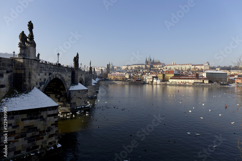 Romantic snowy Prague gothic Castle with the Charles Bridge in the sunny Day,  Czech Republic