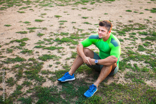 Athlete is resting sitting on the grass