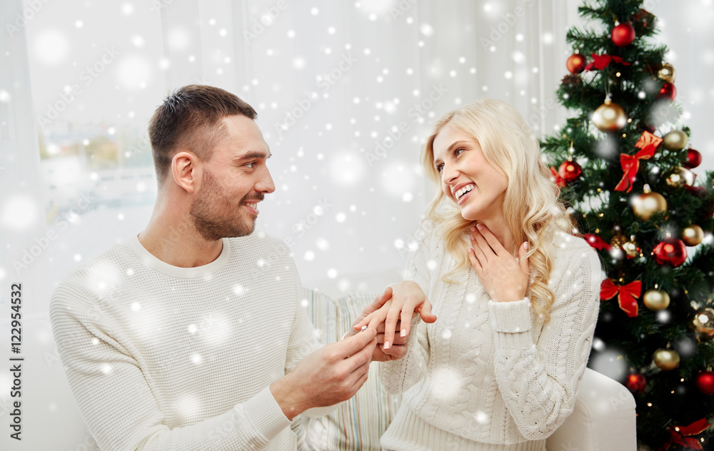 man giving engagement ring to woman for christmas man giving engagement ring to woman for christmas