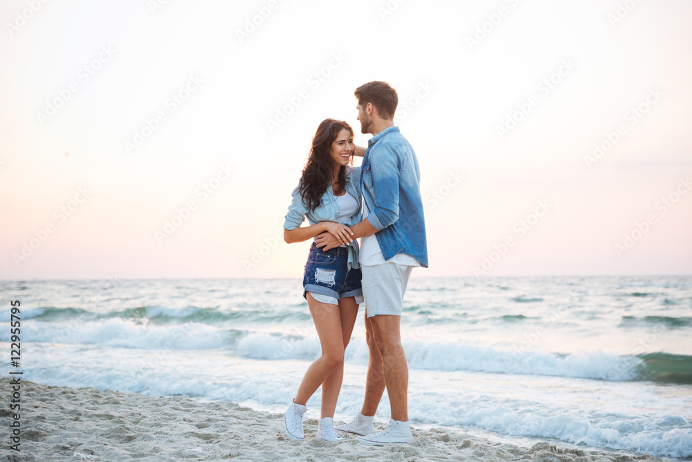 Couple smiling and walking on the beach Couple smiling and walking on the beach
