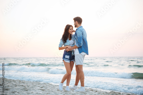 Couple smiling and walking on the beach