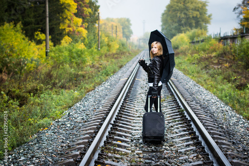 Girl, umbrella and rails in autumn day