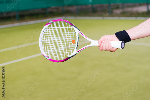 Tennis player's hand holding a racket © kolotype