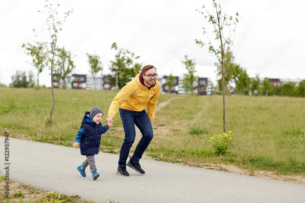 happy father and little son walking outdoors happy father and little son walking outdoors