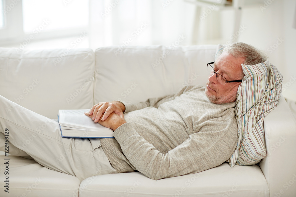 senior man sleeping on sofa with book at home senior man sleeping on sofa with book at home