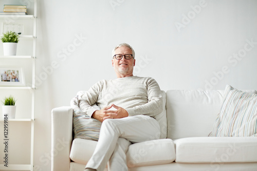smiling senior man in glasses sitting on sofa © Syda Productions