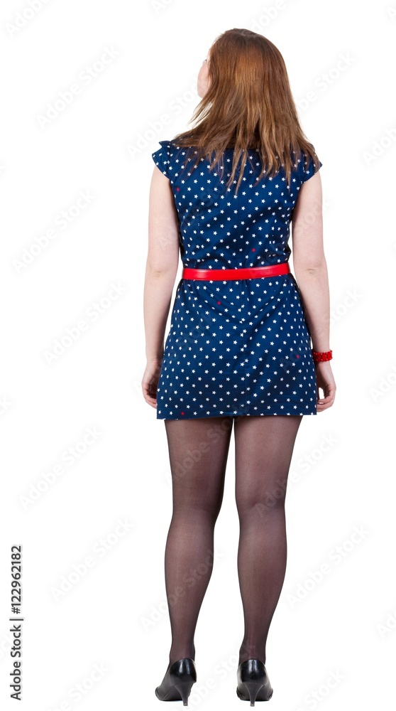 back view of standing beautiful woman. Young blonde girl in blue dress and kitten heels watching;. Rear view people collection. backside view of person. Isolated over white background. back view of standing beautiful woman. Young blonde girl in blue dress and kitten heels watching;. Rear view people collection. backside view of person. Isolated over white background.
