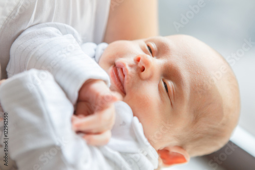 Newborn baby boy asleep in mother's arms
