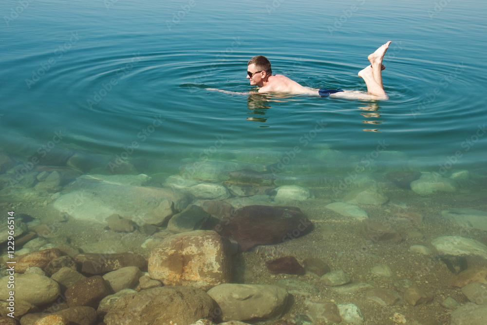 Man at resort Dead Sea. Tourism recreation, healthy lifestyle concept. Copy space.