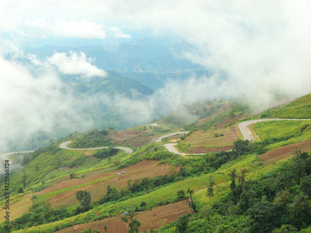 Aerial scene of the curved route to the top of Phu tub berk with the sea of fogs covering the area.