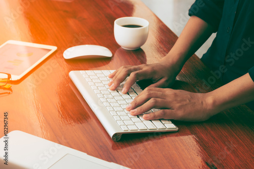 Business woman working with laptop and phone in office.