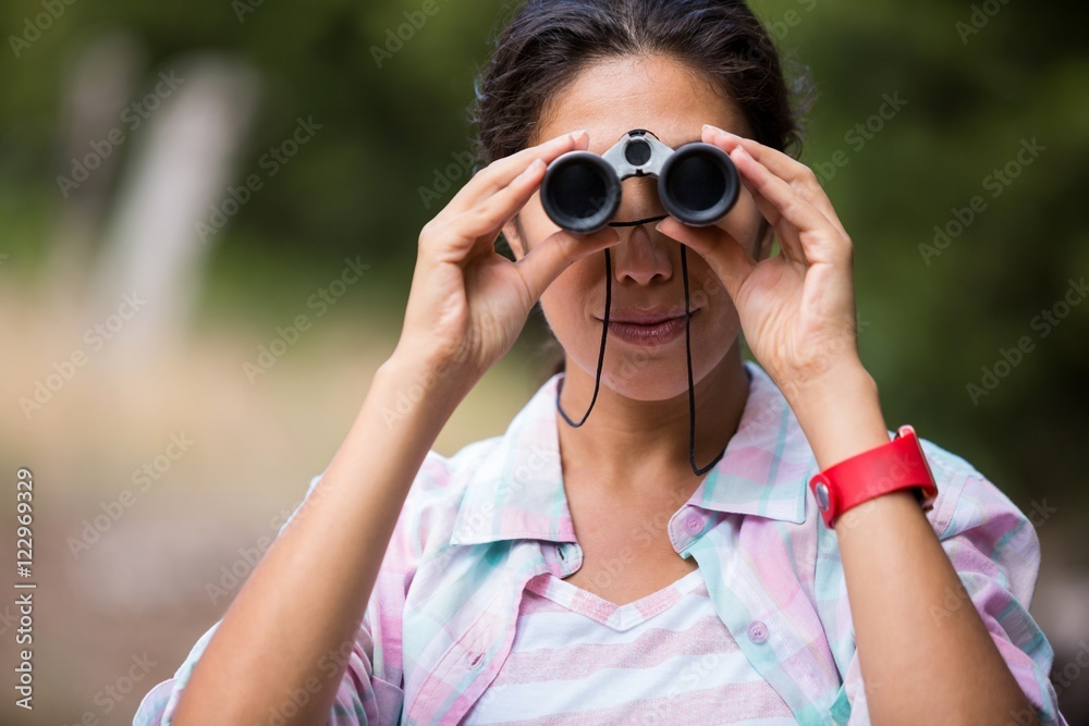 Female hiker looking through binoculars