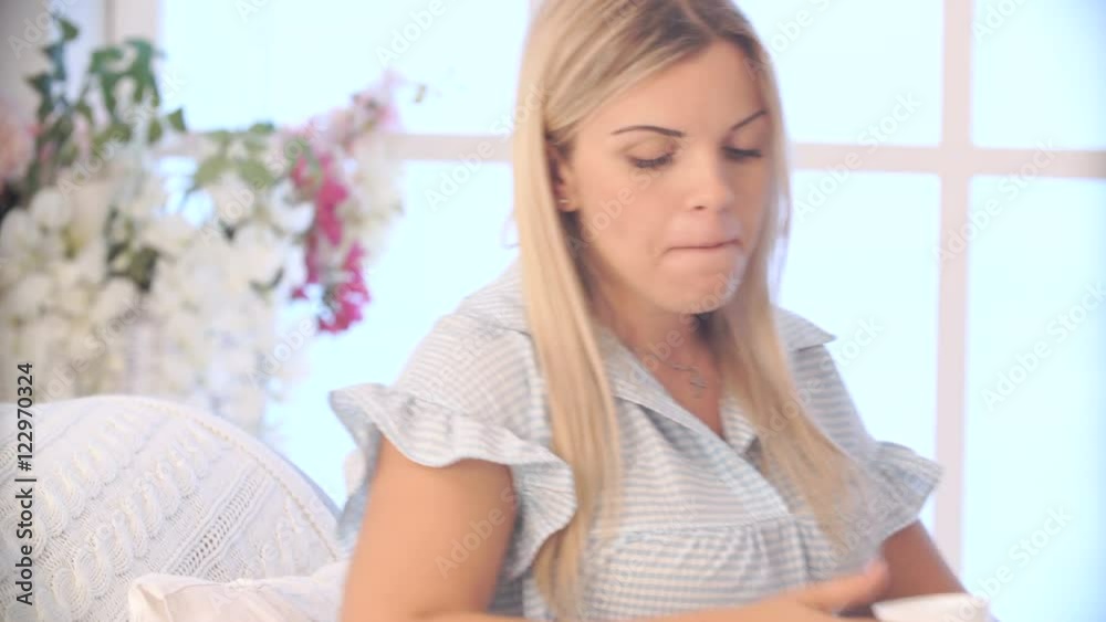 pregnant woman drinking tea and talking on mobile at home pregnant woman drinking tea and talking on mobile at home