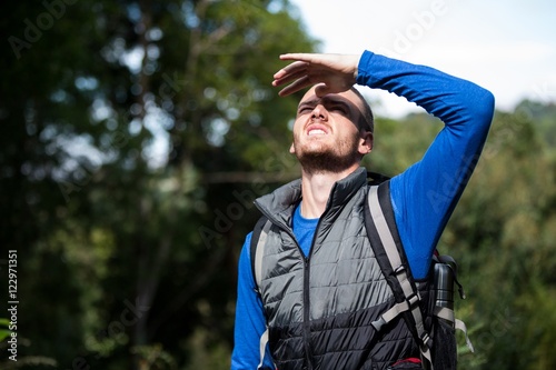 Male hiker shielding his eyes