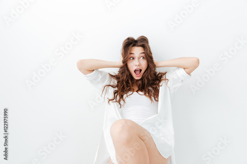 Surprised young woman covering her ears with hands