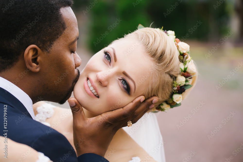 Groom kisses face of bride